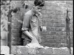 B/W 1961 man smoking cigarette + laying bricks for Berlin Wall / Germany / Cold War / newsreel Stock Footage