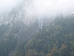 BASE jumper/wing suit flier descends from cliff Stock Footage