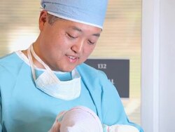 CU TD Doctor in Surgical Scrubs Holding Newborn Baby in Hospital / Richmond, Virginia, USA Stock Footage
