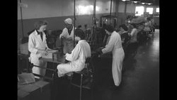 US factory workers load manufactured bullets into boxes during the Korean War News Clip
