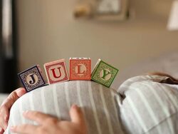 A pregnant women using blocks to spell the month of JULY on her stomach. Stock Footage