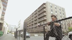 Cool young man with mohawk jumping chainlink fence in city Stock Footage