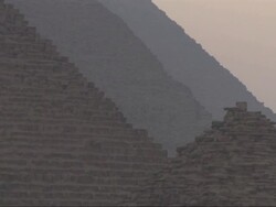 Medium Long Shot, static - Four pyramids are silhouetted against a hazy sky in Egypt Stock Footage