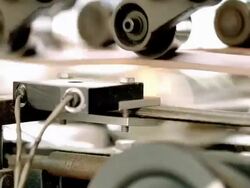 ECU belt driven rollers at industrial can labeling machine as cans roll through and paper labels wrap around cans / Ontario, California, USA  Stock Footage