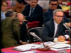 July, 1987 Oliver North sitting next to lawyer talking into microphone during Iran-Contra hearings Stock Footage