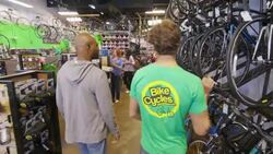 Shop worker walks customer through store and shows off different bike models Stock Footage