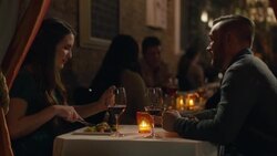 Young couple chats over dinner in romantic candlelit restaurant Stock Footage
