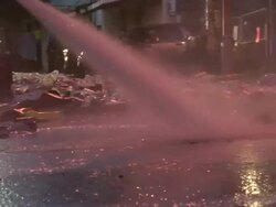 Medium Shot Zoom In - Water spraying trash on dirty street / New Orleans Louisiana Stock Footage