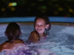 Slow motion shot of girls playing together in hot tub at night / Cedar Hills, Utah, United States Stock Footage