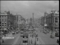 1944: DUBLIN, IRELAND: HA WS Downtown, O'Connell Street w/ statue of Daniel O'Connell in street center, traffic & double-decker trolley cars, Nelson's Pillar distant BG (destroyed 1966), MS People getting off tram on side street w/ O'Connell statue BG Instructional Video
