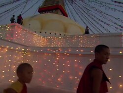 MS PAN Monks walking around  Boudhanath lit up with tiny lights at night  AUDIO / Kathmandu, Central Region, Nepal  Stock Footage