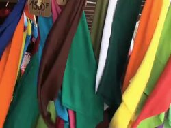 Colorful flapping pareos exposed at a windy market Stock Footage