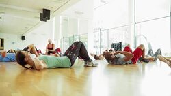 Exercise class doing sit-ups in gym studio Stock Footage