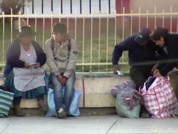People sitting on small wall beside pavement, big yawn, Cochabamba, Bolivia Stock Footage