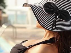 woman in hat taking sunbath near swimming pool Stock Footage