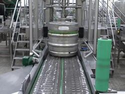 MS Shot of Aluminum beer barrels moving on conveyor at beer production at brewery, Bitburger Pils Stock Footage