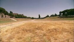 Golden grass stubble covers a field, the site of ancient Rome's Circus Maximus chariot racing track. Stock Footage