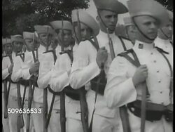 1940: DUTCH NAVY PREPARES: Surabaya Navy base w/ docked ship, soldiers in white uniforms marching, sailors on ship cocking & dry firing anti-aircraft gun. JAVA: VS Dutch submarines. Instructional Video
