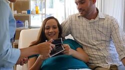 Excited parents-to-be look at sonogram pictures Stock Footage