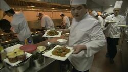 Waiters carry plates of food from a busy restaurant kitchen. Stock Footage