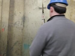 Caucasian factory worker walks through safety screen Stock Footage