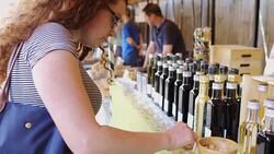 Woman Sampling Vinegar at Farmers Market Stock Footage