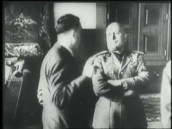 Adolf Hitler and Benito Mussolini speak together and look at a map. News Clip