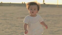 Japanese baby walking on the beach at sanset. Stock Footage