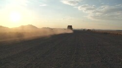 A safari jeep drives through the Namib Desert at golden hour. Stock Footage