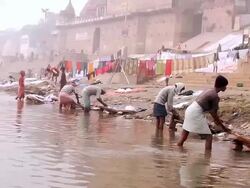 WS People washing clothes in bank of Ganges River / Varanasi, Uttar Pradesh, India Stock Footage