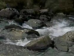 Medium shot of water flowing over rocks and boulders in mountain stream, Brecon Beacons, Wales Stock Footage
