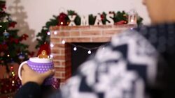 Woman resting with cup of hot drink near fireplace Stock Footage