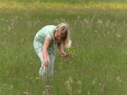 CRANE: Little girl picking flowers Stock Footage