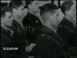 1942: U.S. AIR SQUADRON SCHOOL: INT MS Instructor w/ model airplane talking at blackboard. VS Naval Air Force student pilots in class listening, taking notes. MS Instructor at blackboard ('German battleships') talking, pointing to small model. Instructional Video