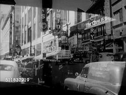 1950: DENVER, COLORADO: POV CAR in city traffic, store signs on commercial buildings, 'Cory', 'Knight Campbell's', 'KOA' , 'Walgreens', 'J.C. Penney Co', 'May Co', 'Porter's', 'Douglas Shoes', people walking sidewalk, cars parked curbside. Instructional Video