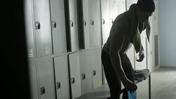Caucasian man wiping sweat from forehead in locker room Stock Footage