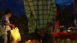 Shoppers pass vendors selling food in a market in India Stock Footage