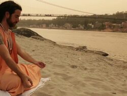 Sage doing padmasana at ganges riverbank, Laxman Jhula, Rishikesh, Uttarakhand, India Stock Footage