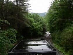 High angle shot of skidder as it drives through the muddy forest. Stock Footage