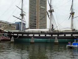 MS Shot of Baltimore Maryland Inner harbor with famous ship USS Consellation historical boat on Chesapeake Bay with coming at water taxi boat / Baltimore, Maryland, United States Stock Footage