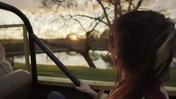 Young woman stares out at scenic landscape from backseat of classic Bronco Stock Footage