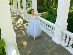 Beautiful ballerina dancing on a park alley with columns Stock Footage