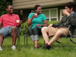 MS Two men and one woman relaxing with beverages on backyard lawn / Portland, Oregon, United States Stock Footage