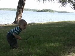 Young boy plays at the edge of lake HD Stock Footage