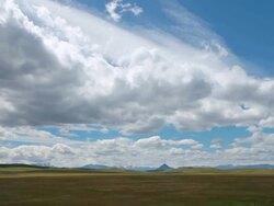 WS T/L View of Dramatic clouds on prairie with Rockie Mountains in back side and sun and shadows rolling across landscape / Augusta, Montana, United States Stock Footage