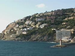 WS View of lighthouse with waterfront town / Mallorca, Balearic Islands, Spain Stock Footage