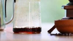 Coffee dripping by pouring hot water into ground coffee beans on paper filter in drip coffee Process Stock Footage