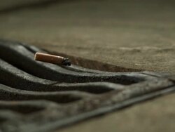 High Speed Cigarette falling in to drain, medium shot Stock Footage