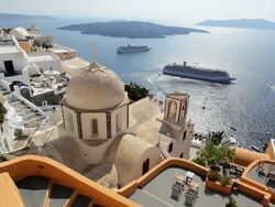 Dome of the local church and the white washed houses of Thira overlooking Cruise ships and the Aegean Sea on the Island of Santorini, Greece, Europe Stock Footage