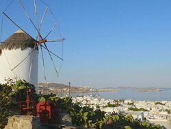 WS View of city at sunrise with white windmill above city white village port Greek / Mykonos, Greece Stock Footage